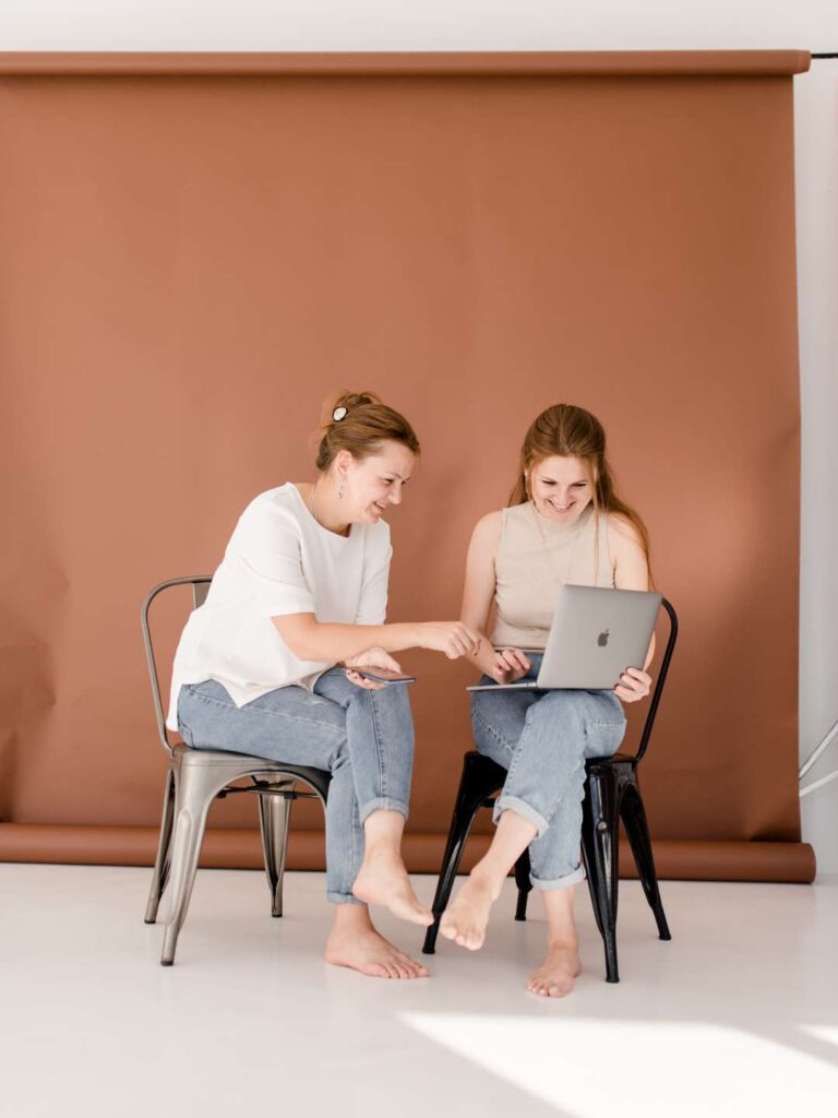 SibilleK Blogbeitrag. Fotocredit Darlingstock. 2 Frauen sitzen barfuss zusammen.