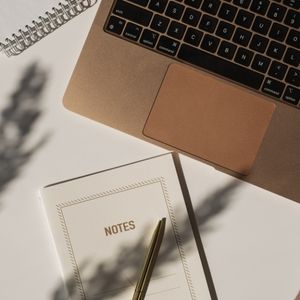 Laptop mit Notizheft und Stift. Fotocredit Canva