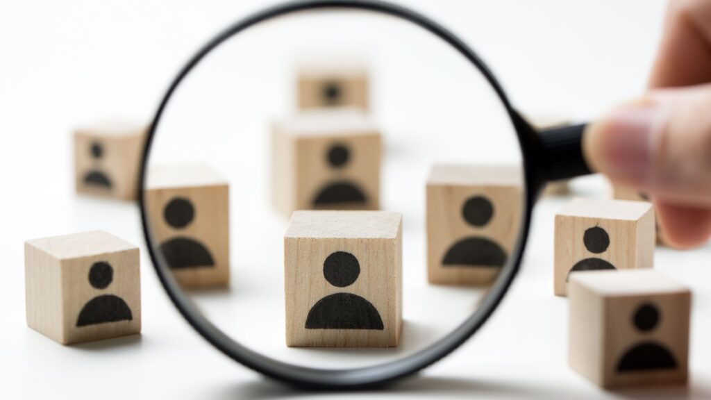 Mehr Direktbuchungen durch Suchintention statt Keyword-Optimierung  Fotocredit Canva
Holzelemente mit Icons, die Menschen darstellen. Eine Lupe die hervorhebt.  Blog: sibilleK