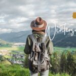Website im Winterschlaf? Foto zeigt Frau in Wanderbekleidung mit Blick ins Tal und Berge Fotocredit Canva @SibilleK